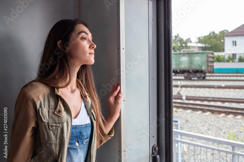 Free Download a young girl looks out of the train door. the girl goes on vacation - GFXLoad