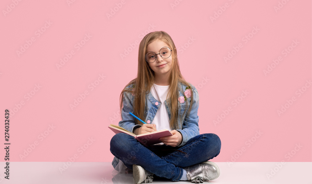 Smiling girl writing in notebook Smiling girl writing in notebook