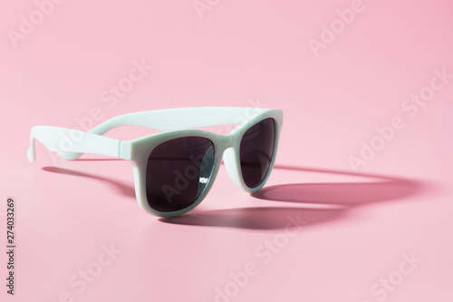 Sun glasses with shadow on punchy pink. Copy space. Summer concept.