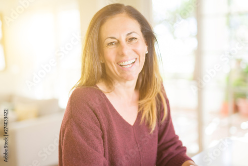 Beautiful middle age woman smiling at home