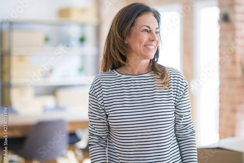 Beautiful middle age senior woman standing looking away to side with smile on face, natural expression. Laughing confident.