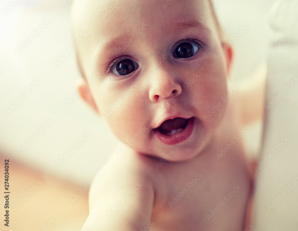 childhood, babyhood, emotions and people concept - close up of happy little baby boy or girl at home childhood, babyhood, emotions and people concept - close up of happy little baby boy or girl at home