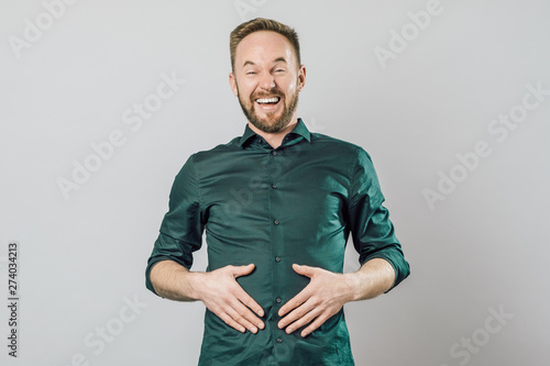 Portrait of young handsome man with beard smiling laughing