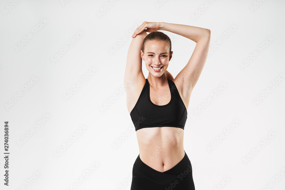 Image of adorable sporty woman wearing tracksuit stretching her arms with eyes closed while doing aerobics Image of adorable sporty woman wearing tracksuit stretching her arms with eyes closed while doing aerobics