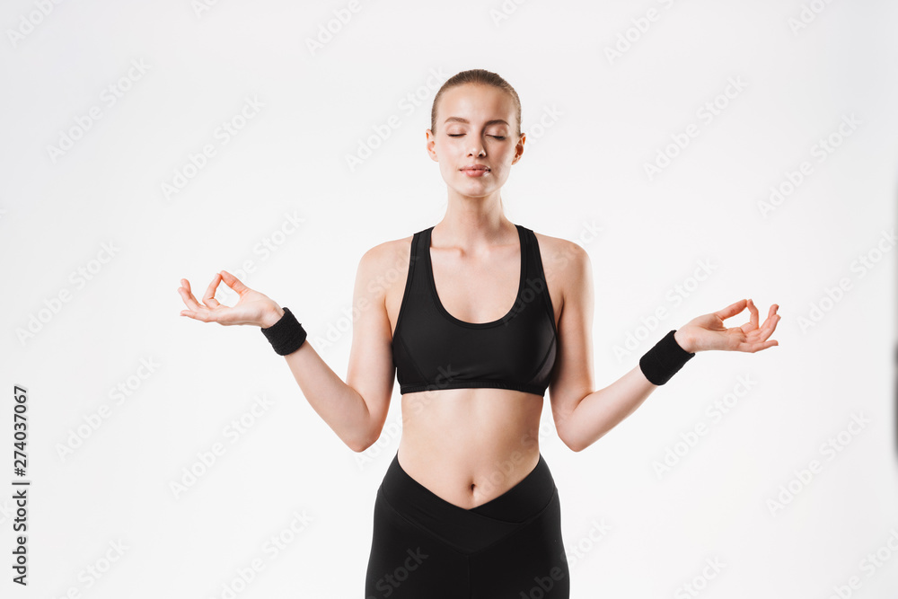 Image of caucasian calm woman wearing tracksuit meditating with eyes closed and zen fingers Image of caucasian calm woman wearing tracksuit meditating with eyes closed and zen fingers