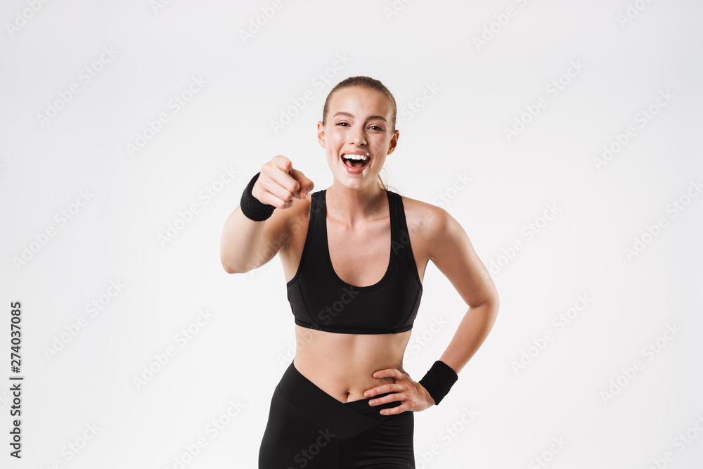 Image of nice amazed woman wearing tracksuit looking and pointing fingers at camera Image of nice amazed woman wearing tracksuit looking and pointing fingers at camera
