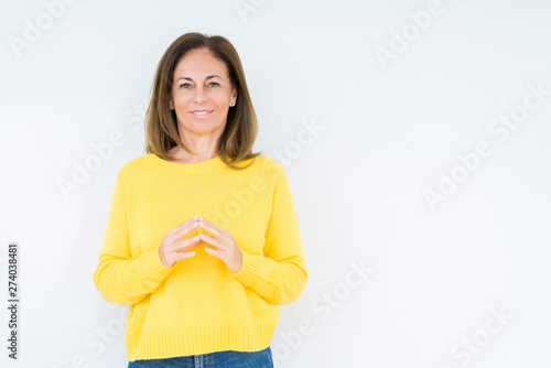 Beautiful middle age woman wearing yellow sweater over isolated background Hands together and fingers crossed smiling relaxed and cheerful. Success and optimistic