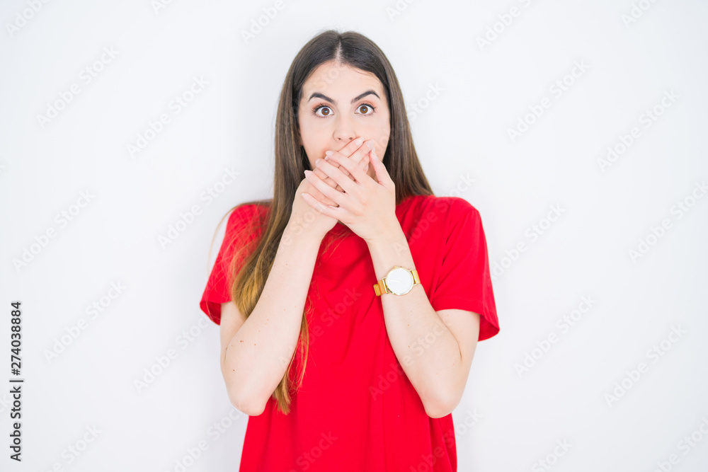 Young beautiful woman wearing casual red t-shirt over white isolated background shocked covering mouth with hands for mistake. Secret concept. Young beautiful woman wearing casual red t-shirt over white isolated background shocked covering mouth with hands for mistake. Secret concept.