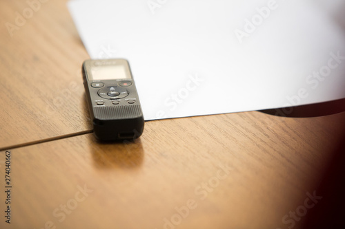Digital sound recorder and other accessories on the wooden table, top view