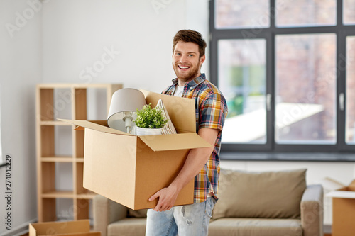 Fotografie moving, people and real estate concept - happy man with boxes at new home