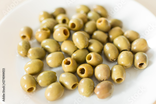Pickled green olives in a plate on a white background. Olives, healthy eating. Italian cuisine.