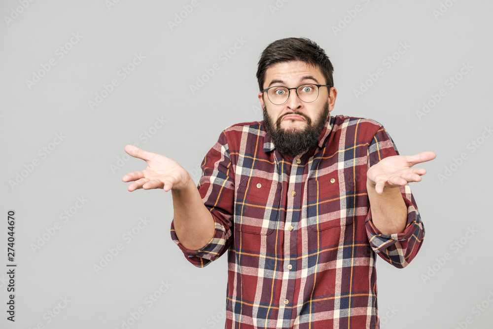 Portrait of handsome guy looking upside and shrugging his shoulders Portrait of handsome guy looking upside and shrugging his shoulders