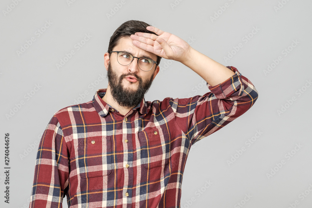 Portrait of young tired caucasian guy wiping his forehead with hand Portrait of young tired caucasian guy wiping his forehead with hand