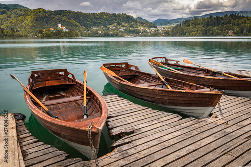 scenic view on beautiful wooden flat rowing boats on lake bled, slovenia, go green concept