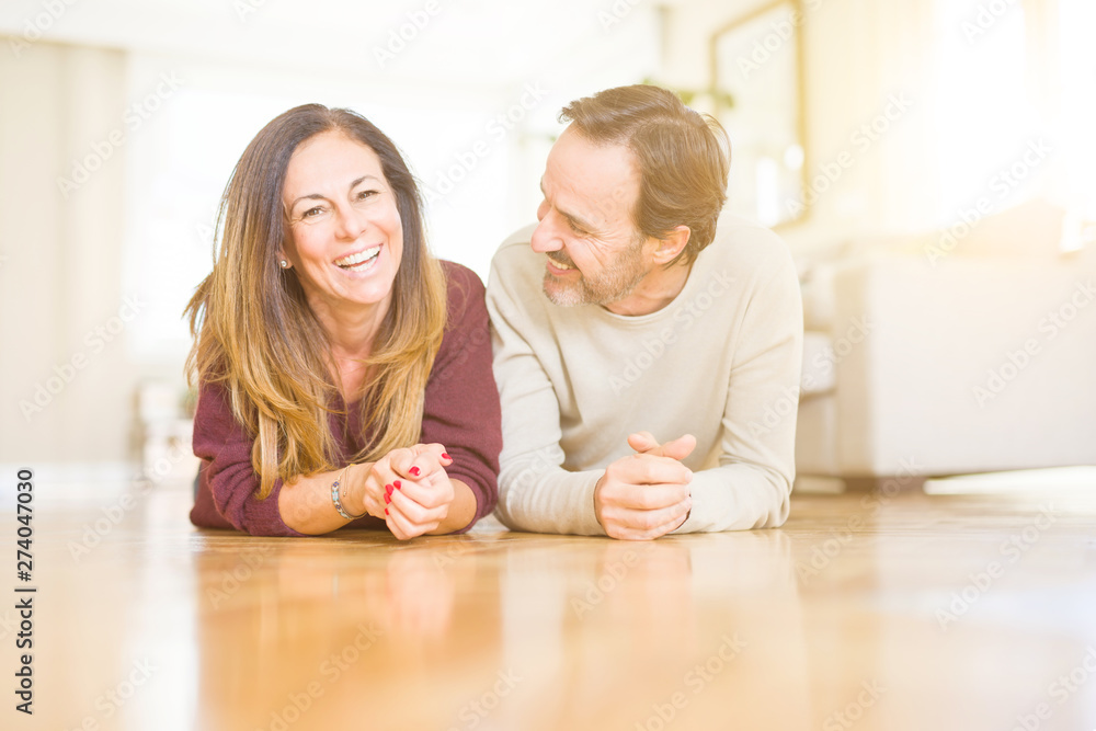 Beautiful romantic couple sitting together on the floor at home Beautiful romantic couple sitting together on the floor at home