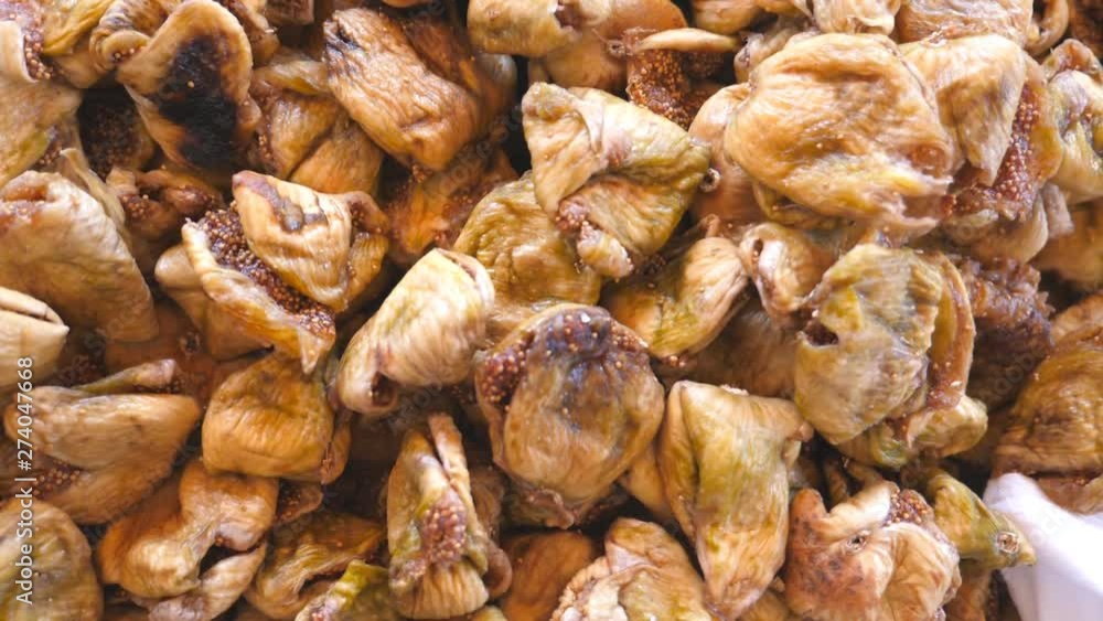 Detail view on pile of dried figs. Close up of falling sweet and tasty berries. Healthy food concept. Slow motion Top view