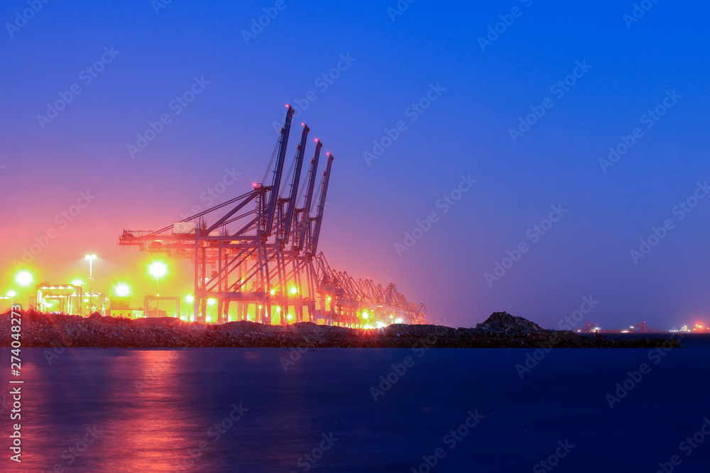 Obraz premium Cranes at the cargo terminal in the evening