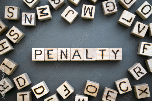 the word penalty wooden cubes with burnt letters, penalty for tax evasion, gray background top view, scattered cubes around random letters