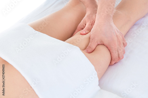 Close-up of masseur doing massage of young woman's legs during spa procedures at beauty salon