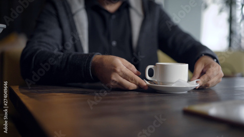 mans hands and glass cup of medicine herbal tea