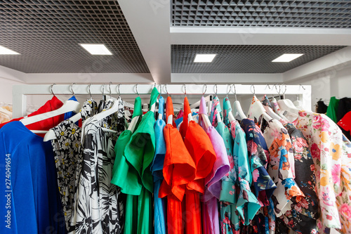 Cocktail dress. Clothing on hanger at the modern shop boutique. Bright multi-colored fabrics. concept of shopping.