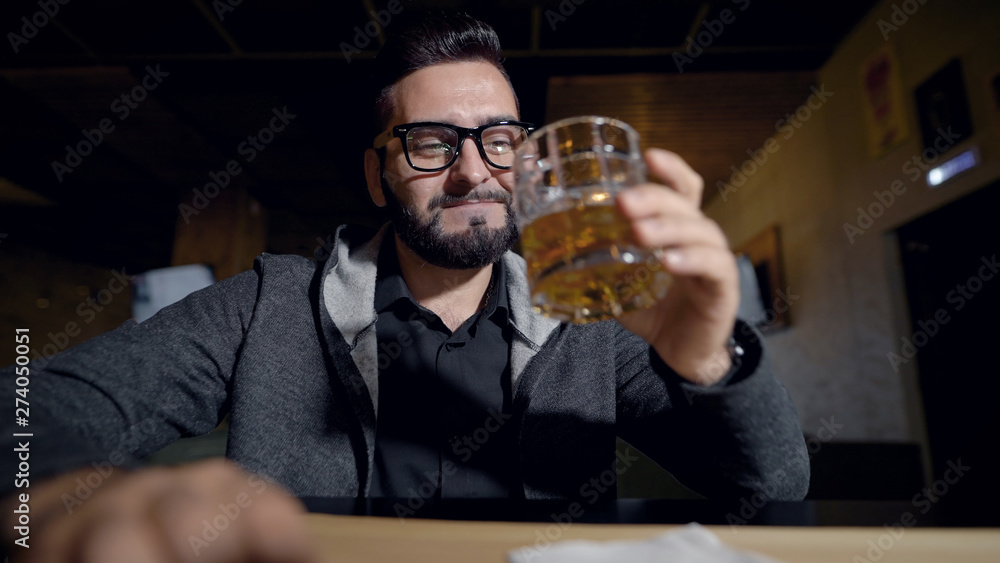 Portrait handsome stylish guy in glasses with glass of whiskey, cheers in camera. Portrait handsome stylish guy in glasses with glass of whiskey, cheers in camera.