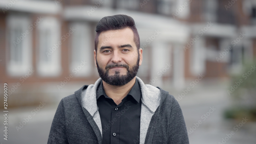 Outdoor portrait of young handsome smiling man with beard Outdoor portrait of young handsome smiling man with beard