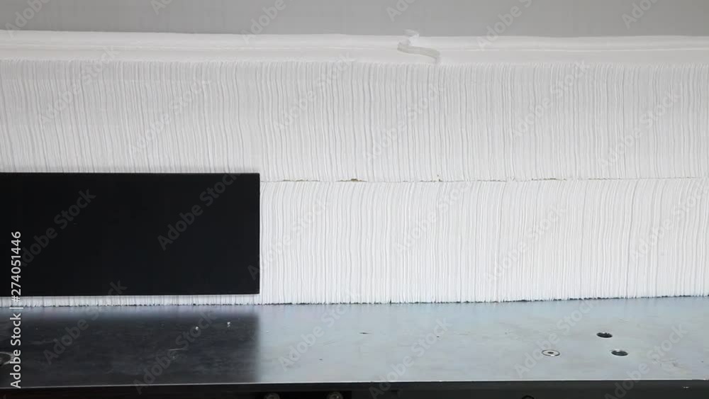Production of white napkins in factory, close up Production of white napkins in factory, close up