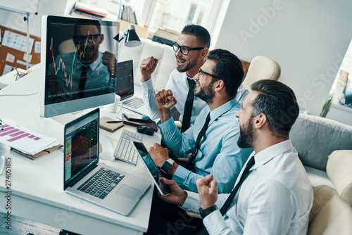 Wallpaper Mural Success! Group of young modern men in formalwear gesturing and smiling while working in the office Torontodigital.ca