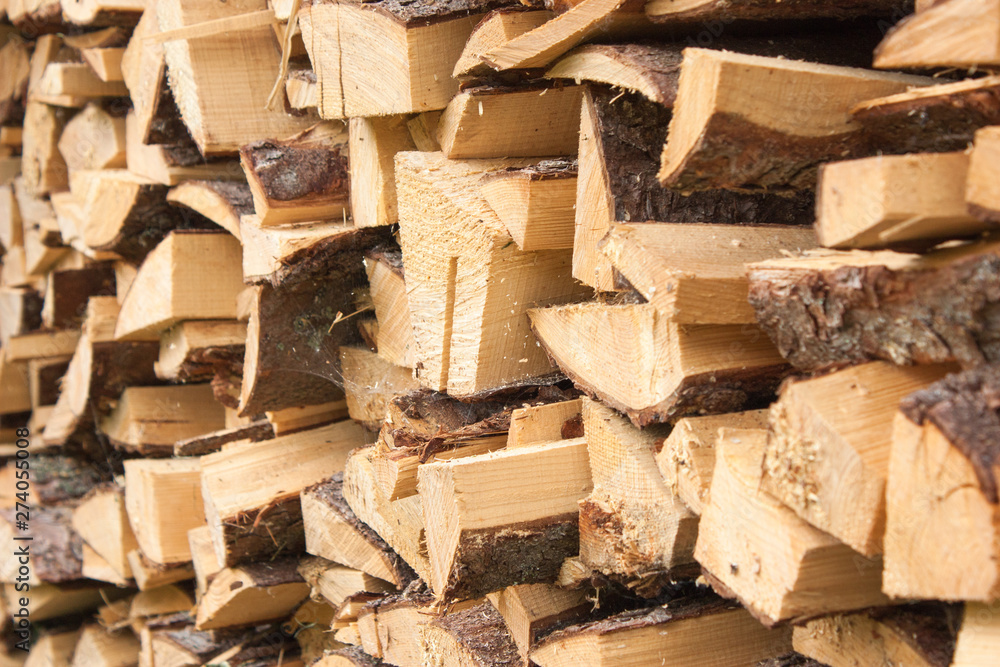 Wood for the village stove or fireplace stacked in a stack. Dry wood texture. Ecologically clean fuel. Selective focus. Wood for the village stove or fireplace stacked in a stack. Dry wood texture. Ecologically clean fuel. Selective focus.