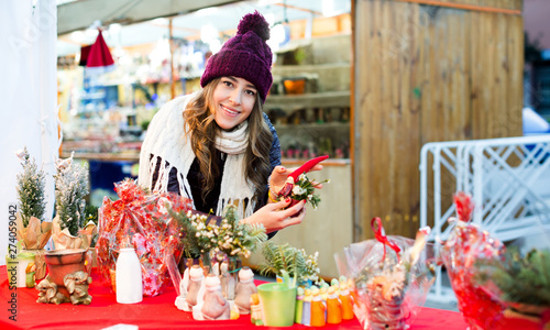 Girl buying floral compositions at Christmas market photo