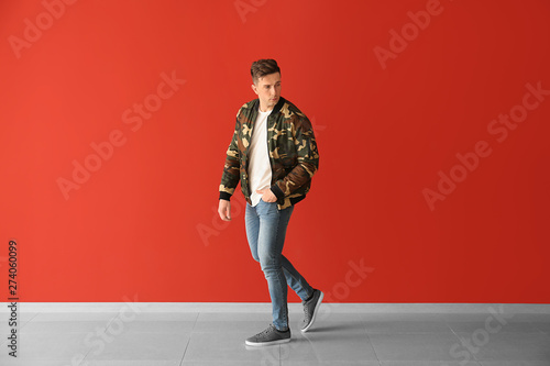 Fashionable young man near color wall