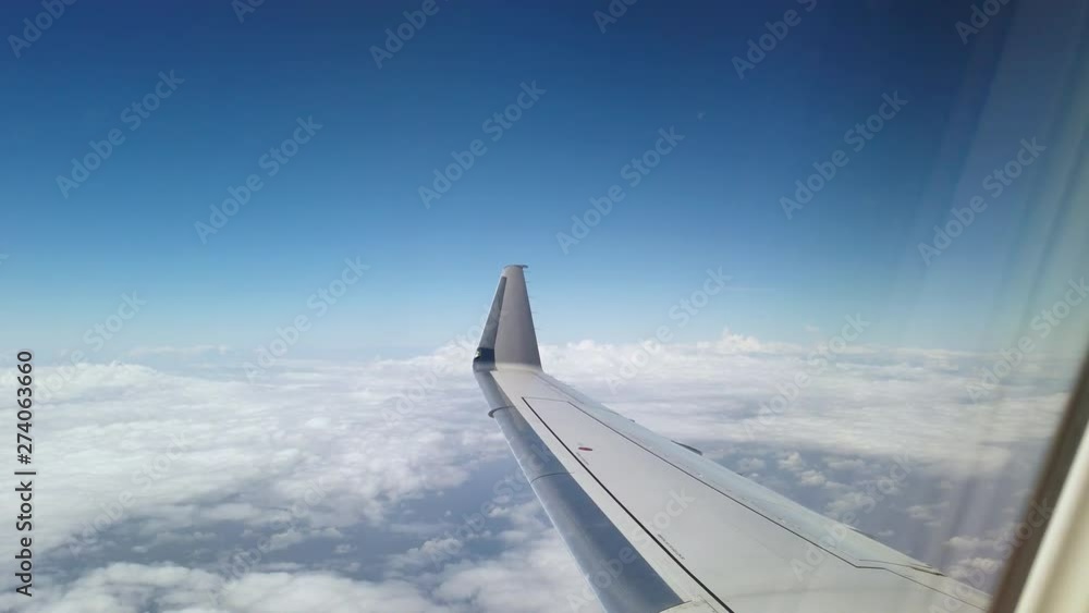Wing of an airplane flying above the clouds Wing of an airplane flying above the clouds