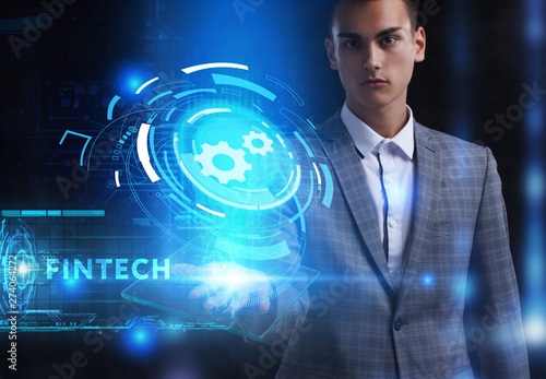 The concept of business, technology, the Internet and the network. A young entrepreneur working on a virtual screen of the future and sees the inscription: Fintech