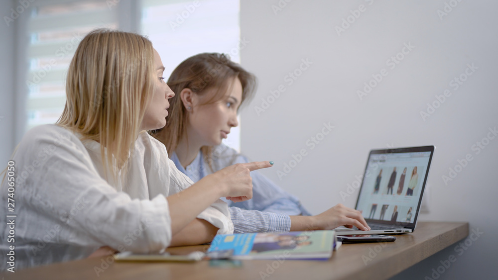 Two girls shopping online at home, choosing clothes on internet site, stylish clothes. Two girls shopping online at home, choosing clothes on internet site, stylish clothes.