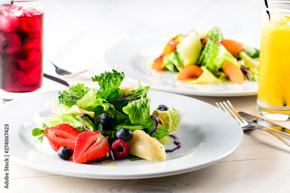 summer breakfast of fresh salad with berries, fruit and cheese and juice summer breakfast of fresh salad with berries, fruit and cheese and juice