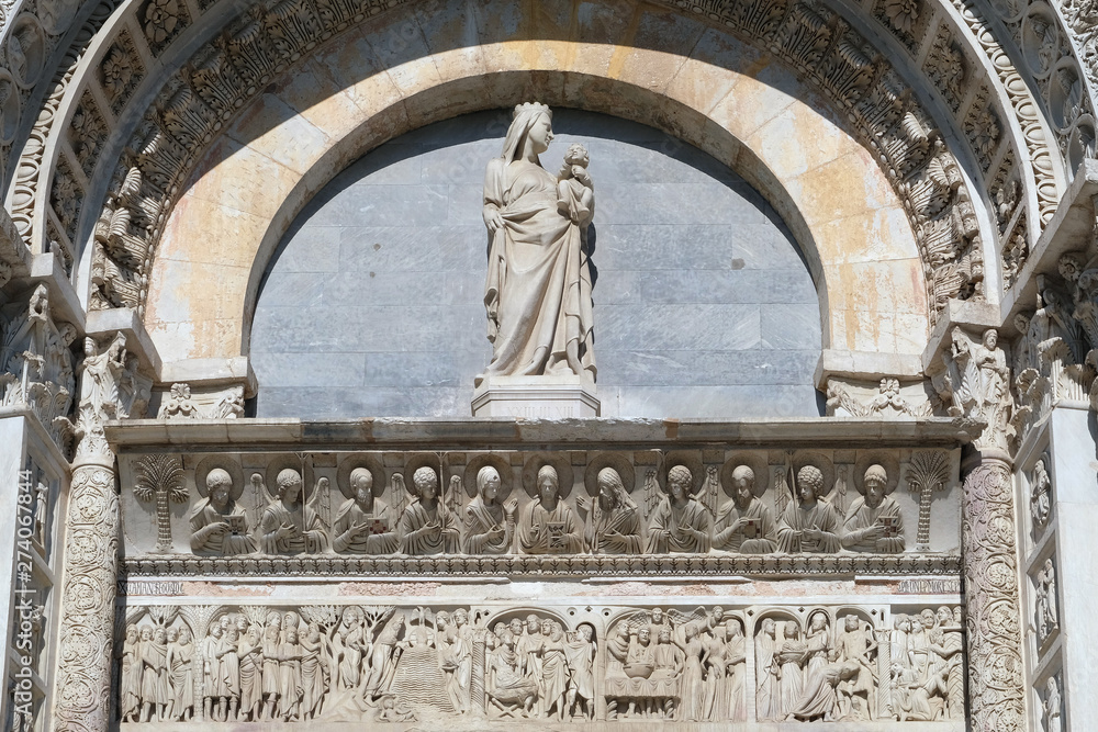 Virgin Mary with baby Jesus above Entrance Door of Cathedral Church Baptistery in Pisa, Italy