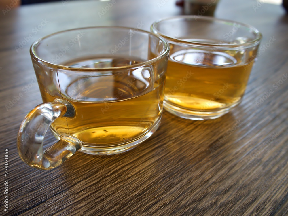 Burmese (Myanmar) style tea in the clear cup on the wooden table Burmese (Myanmar) style tea in the clear cup on the wooden table