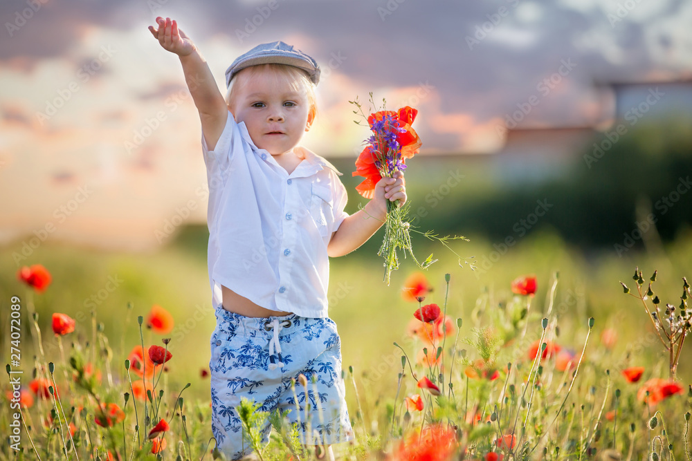 Happy beautiful toddler child, holding bouquet of wild flowers on sunset Happy beautiful toddler child, holding bouquet of wild flowers on sunset