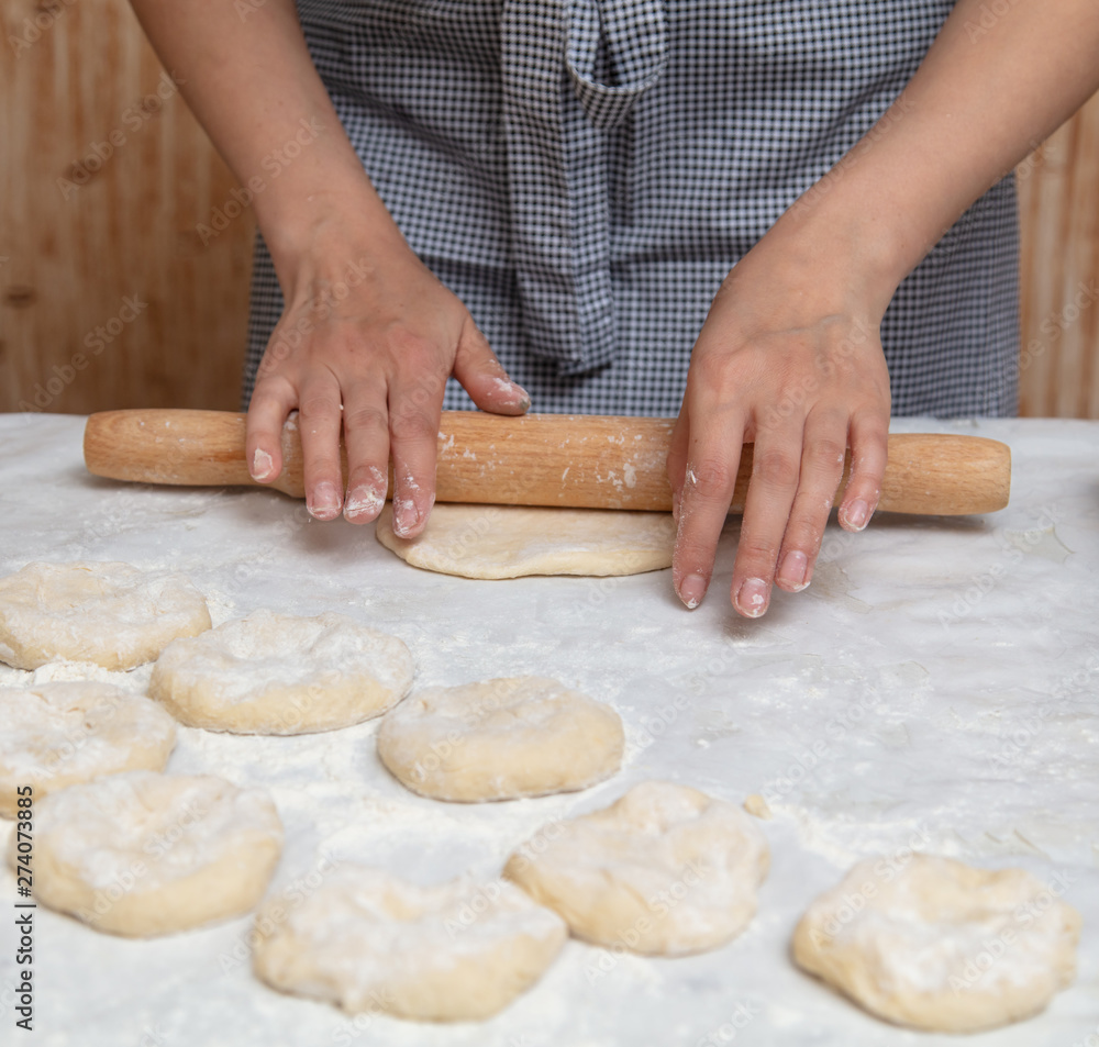 Girl rolls the dough in the kitchen Girl rolls the dough in the kitchen