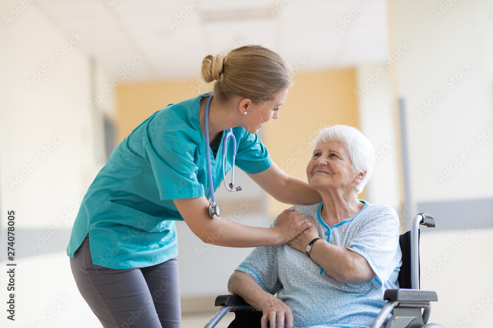 Obraz premium Senior woman in wheelchair with nurse in hospital