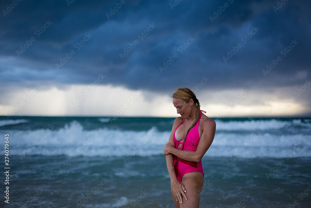 Fitness model on the beach at storm Fitness model on the beach at storm