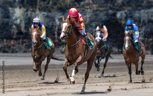 Close up on lead race horse and jockey galloping towards the finish line, race horse action on the beach © Gabriel Cassan