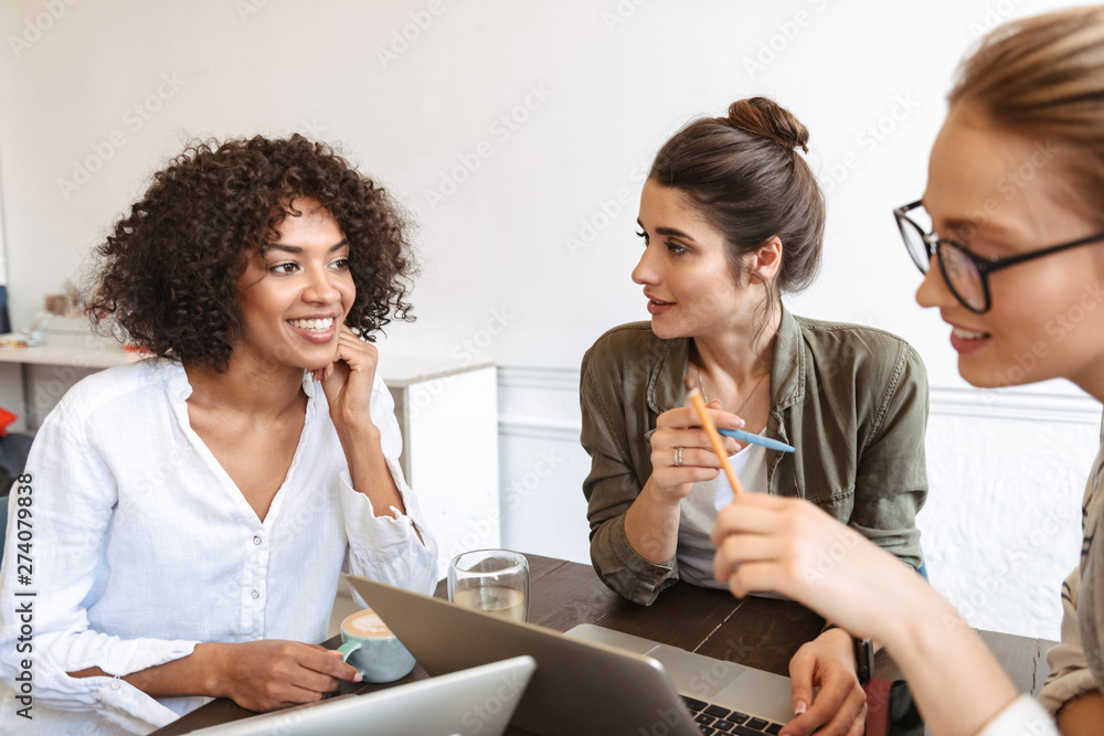 Group of cheerful young women studying together Group of cheerful young women studying together