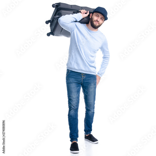 Man in jeans holding throws travel suitcase standing on white background isolation