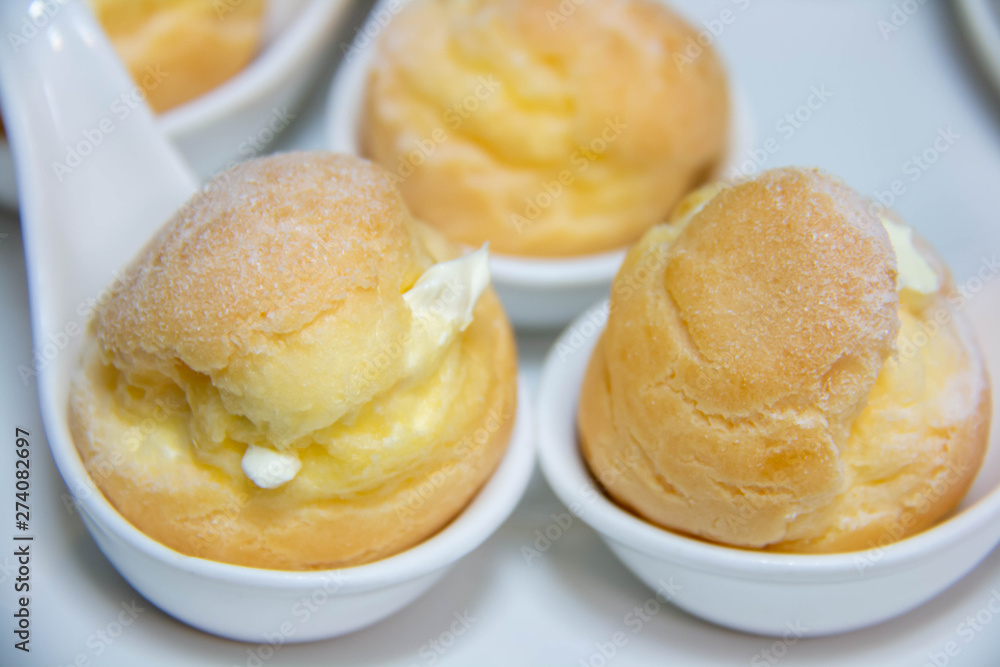 delicious vanilla eclair on white spoon. delicious vanilla eclair on white spoon.