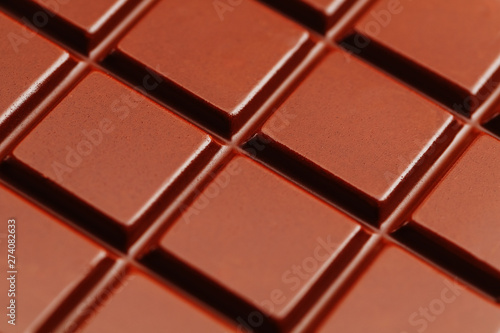 Texture of dark chocolate close up. Segments of a chocolate bar in macro. Full frame texture