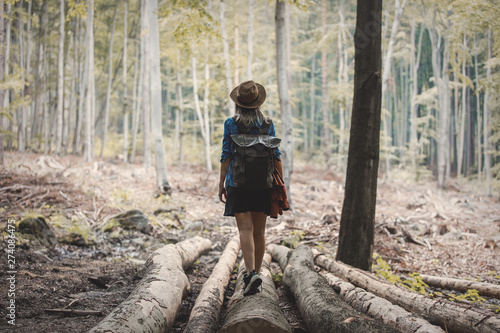 Style girl in hat with backpack in a summer time Mixed coniferous forest