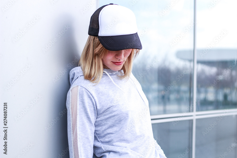 The girl is blonde in a gray sports suit. Street clothing. Sport. Advertising. Fashion and style. Trends. Mockup. Copyspace