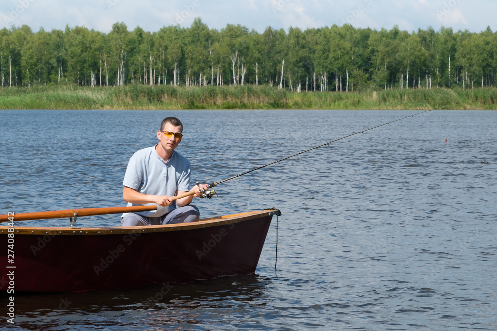 the fisherman sits in a boat on the river and catches fish for a bait, a weekend in nature